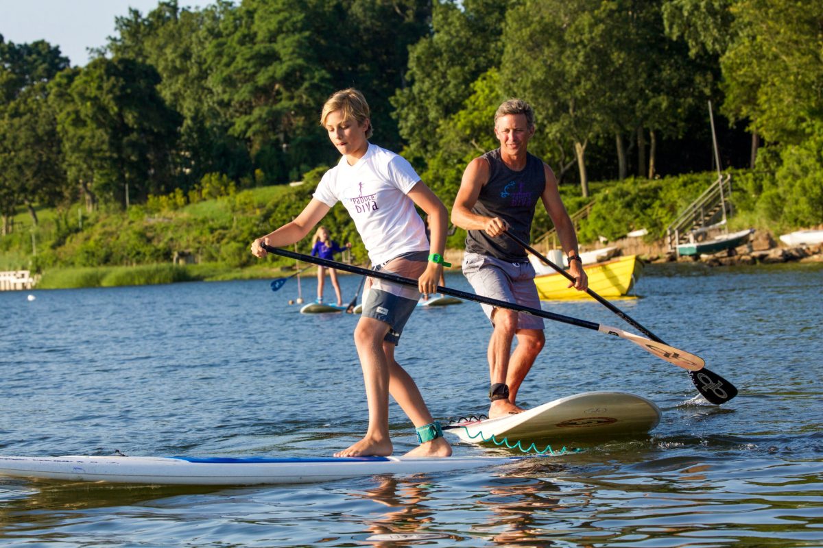 a group of men standing next to a body of water