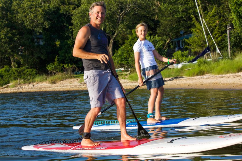 a group of men standing next to a body of water
