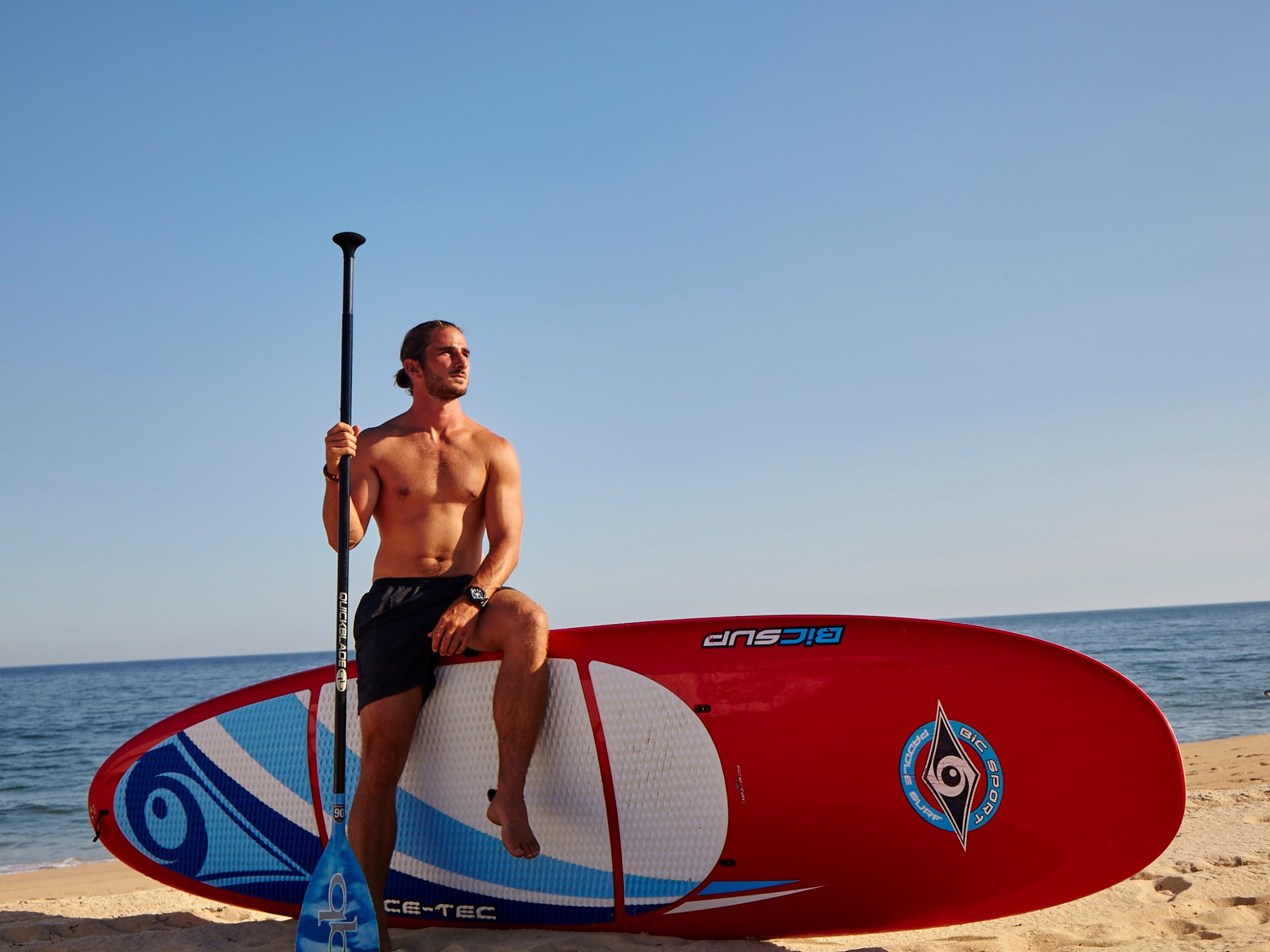 a man carrying a surf board on a body of water