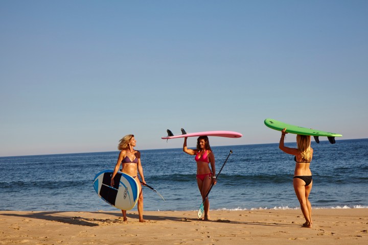 a person carrying a surf board on a beach