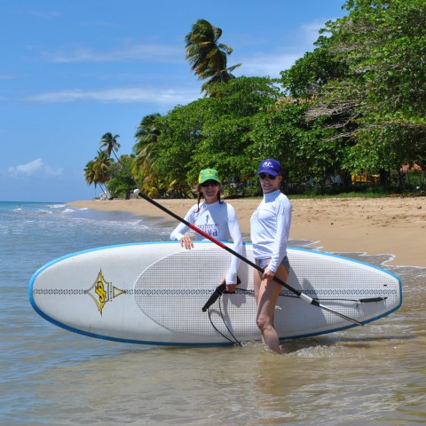 a man carrying a surf board on a body of water
