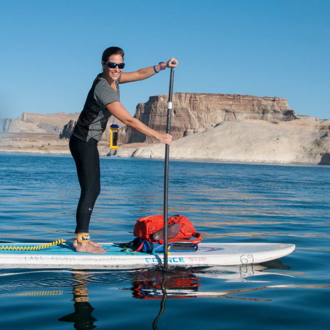 a man and a woman standing in water holding a surfboard
